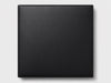 A square black textured panel or cover with rounded corners, shown flat against a light gray background.