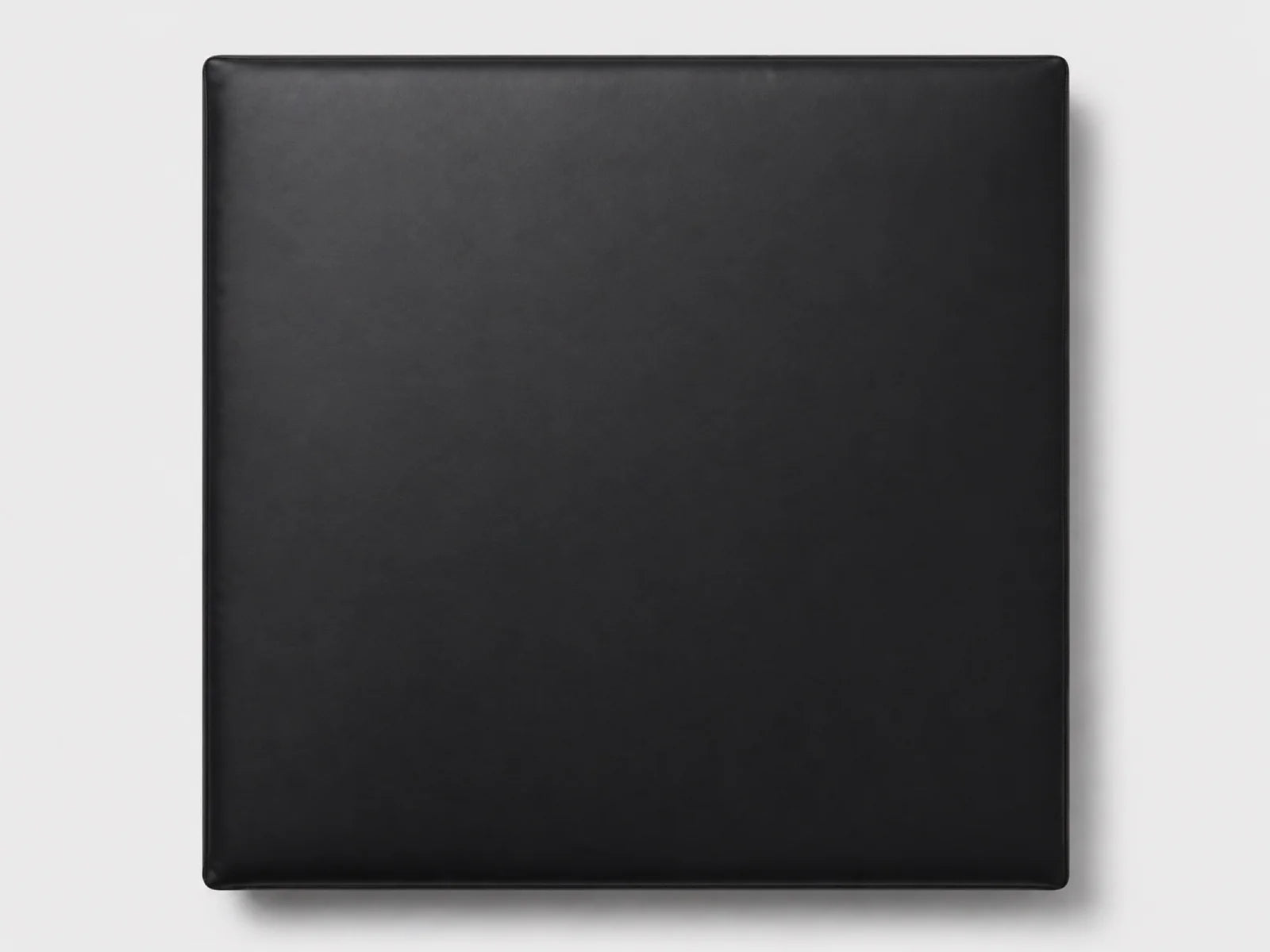 A square black textured panel or cover with rounded corners, shown flat against a light gray background.