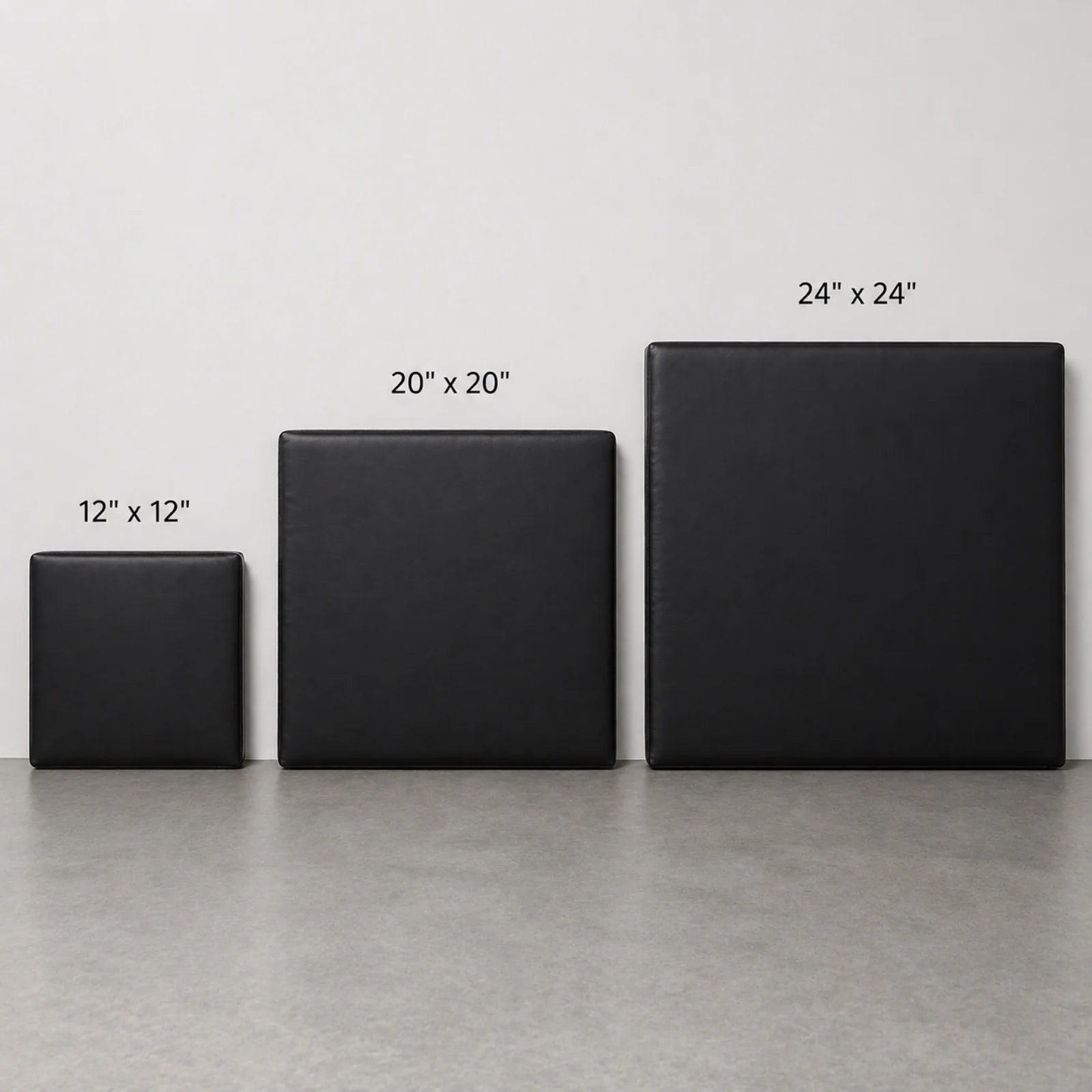 Three square black upholstered panels or mats shown in increasing sizes labeled 12 x 12 inches, 20 x 20 inches, and 24 x 24 inches, against a light gray wall and concrete floor.